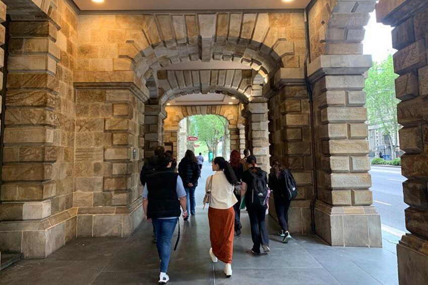 A stone archway with people walking through it. 4