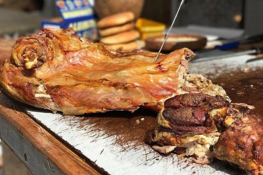 A roasted chicken on a wooden cutting board with a knife. 3