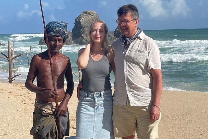 Ein Strand mit Wellen, einem Felsen und einer Person, die eine Angel hält. 3