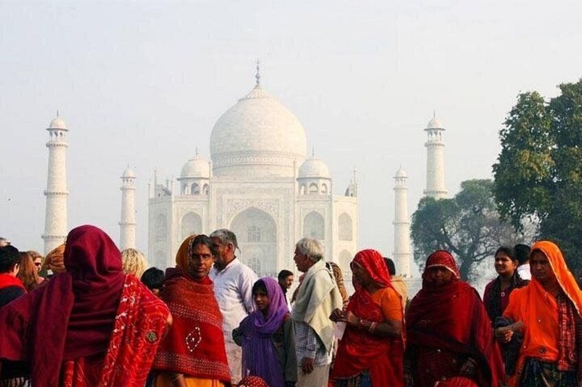 Das Taj Mahal mit Personen in traditioneller Kleidung im Vordergrund. 2
