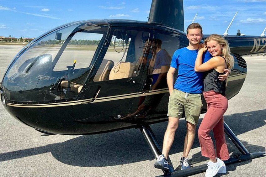 En helikopter parkeret på en startbane med en person stående ved siden af den. 3
