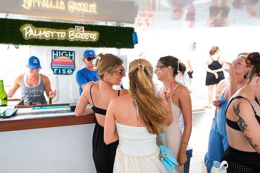 A bar named 'Palmetto Breeze' with a sign indicating 'HIGH RISE' and people standing at the bar. 3