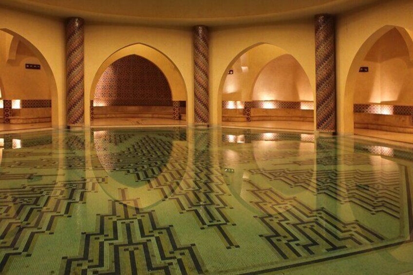 A large indoor pool with patterned floor tiles and arched ceilings. 4