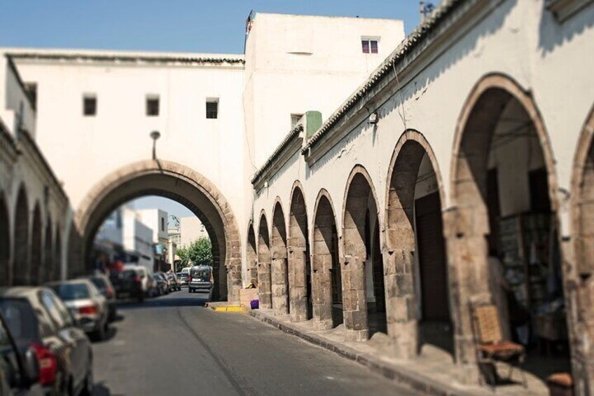 A street with an arched bridge and buildings with arches. 5