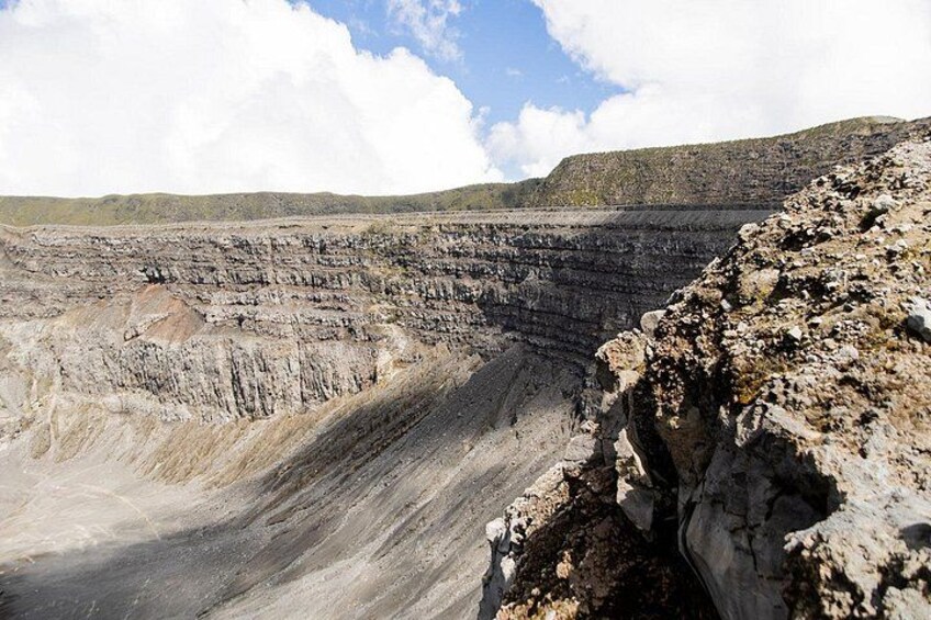 A large open-pit mine with steep, layered walls and a flat, barren landscape. 4