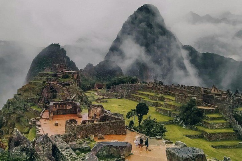 Machu Picchu ruins, terraced fields, and mist-covered mountains. 2