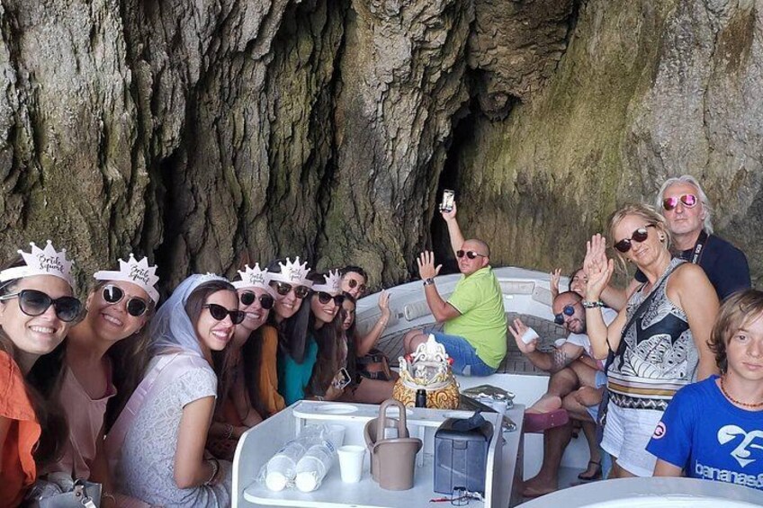 Un groupe de personnes se trouve dans un bateau, près d’une grotte rocheuse. 3