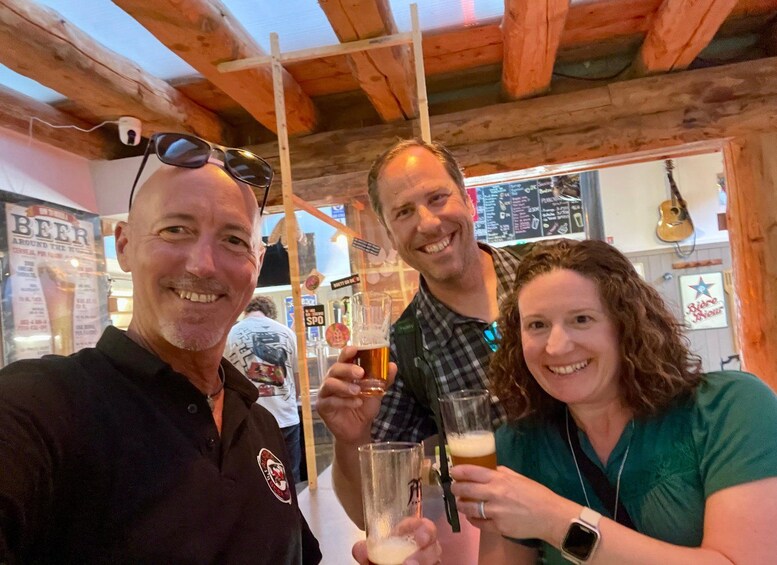 A group of people toasting with beer glasses in a wooden interior setting. 5