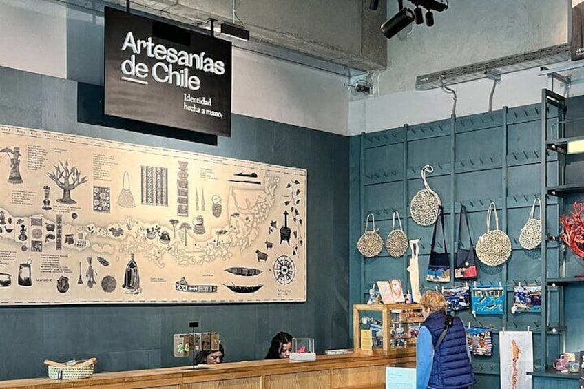 A store interior with a large wall display of Chilean crafts and a sign reading "Artesanías de Chile". 4