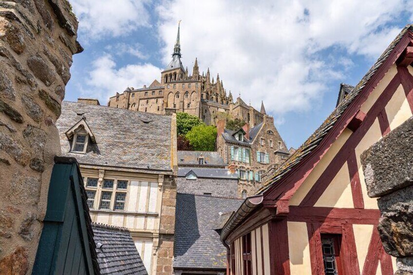 A historic building with a spire, surrounded by traditional half-timbered houses. 5
