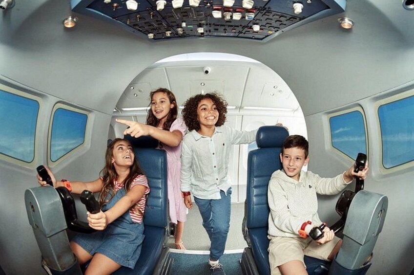 Interior de un avión con pasajeros sentados y de pie, sosteniendo cámaras. 2