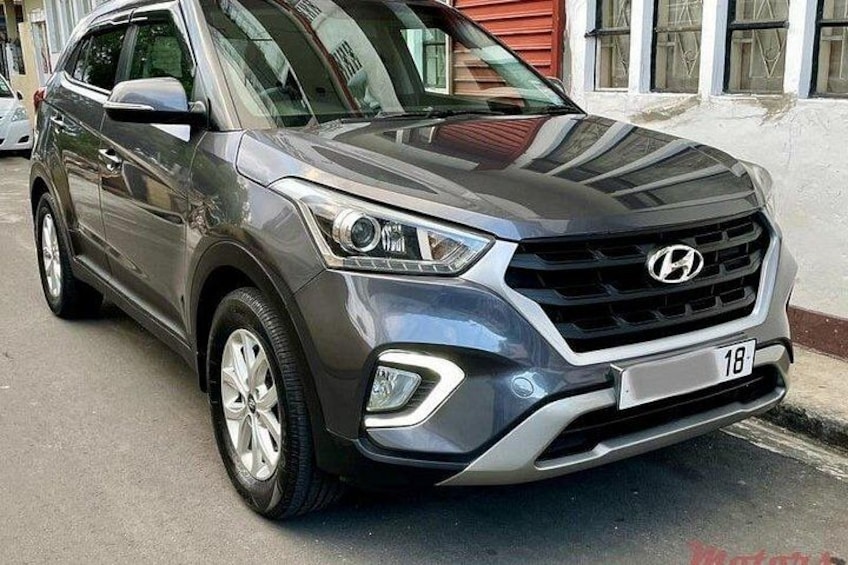 Een grijze Hyundai SUV geparkeerd op een straat. 1