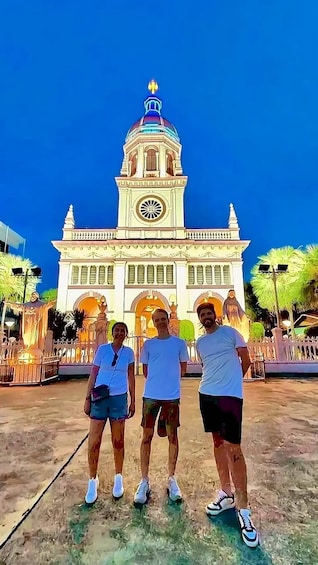 A group of people standing in front of a historic building with a clock tower. 3