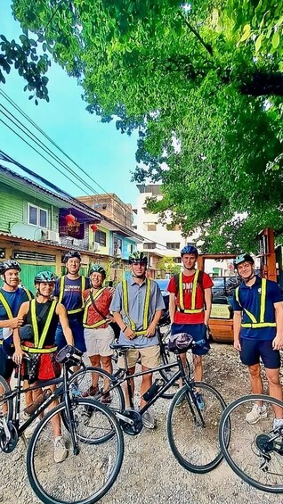 A group of cyclists with bicycles on a street lined with buildings. 5