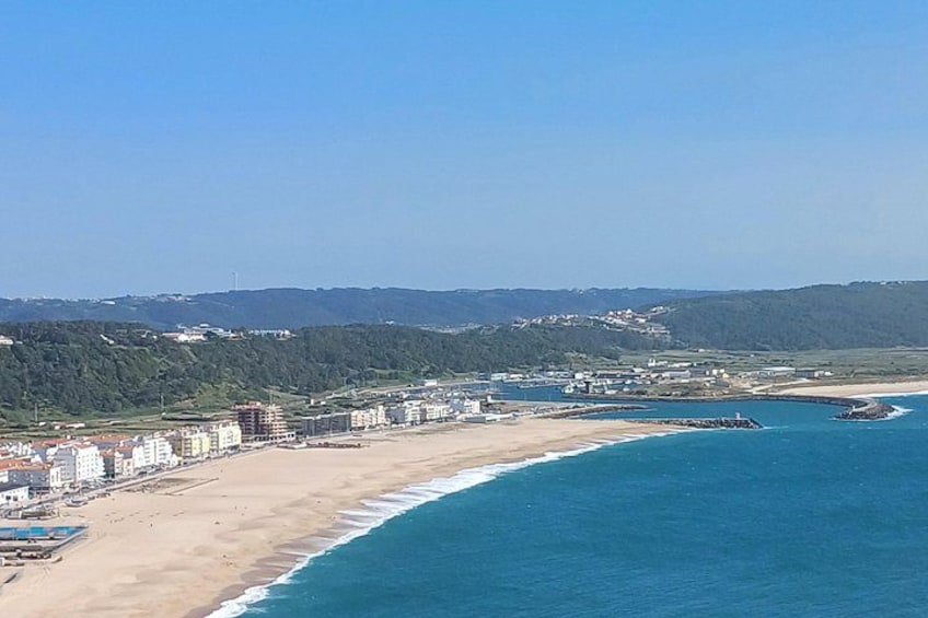 Un paisaje urbano costero con playa, edificios y un faro. 5