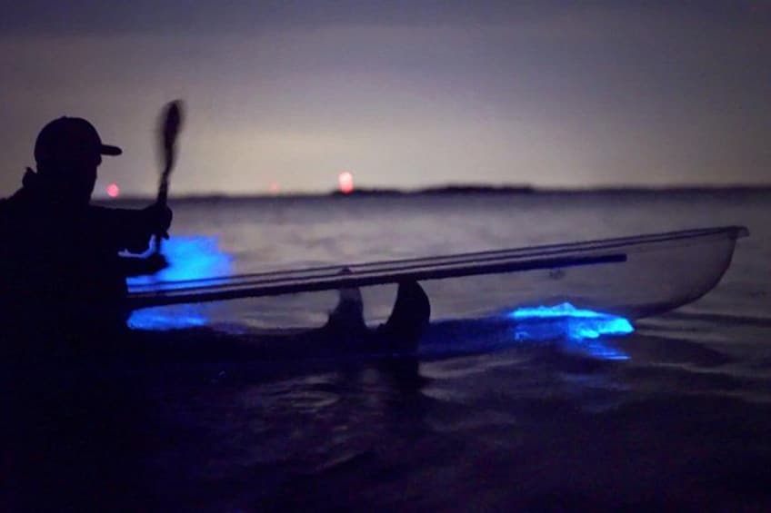 Ein Kajak mit blauen Lichtern auf dem Wasser in der Nacht. 1