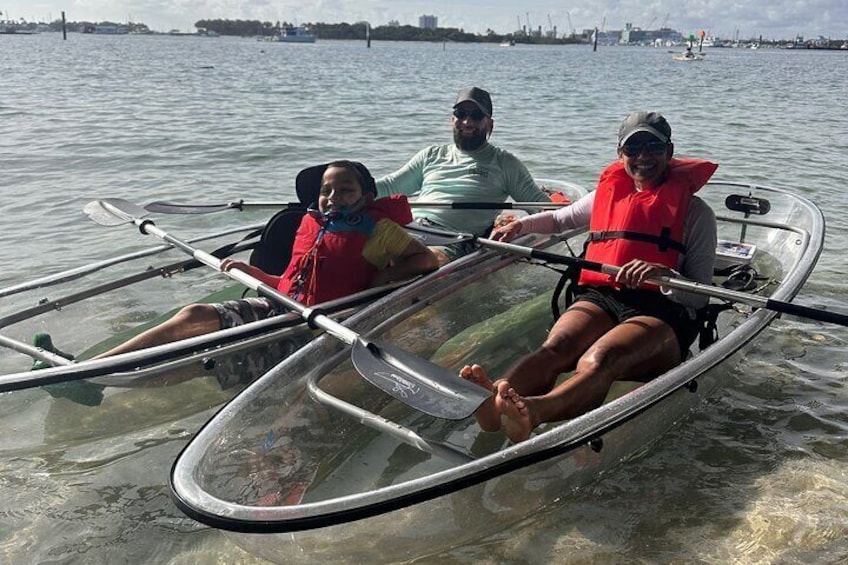 Trois personnes se trouvent dans un bateau transparent sur une étendue d’eau. 1