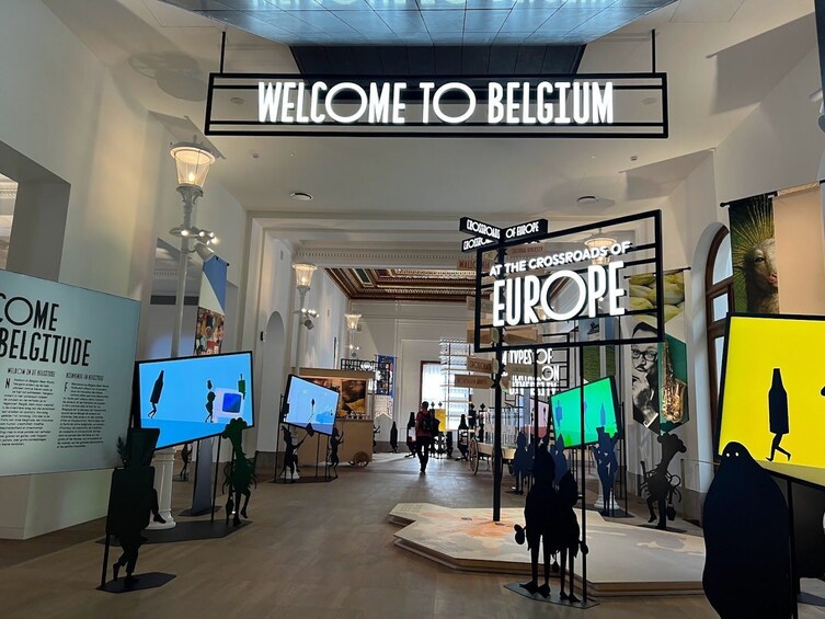 Een museuminterieur met de tekst 'WELCOME TO BELGIUM', tentoonstellingen en de tekst 'AT THE CROSSROADS OF EUROPE'. 5
