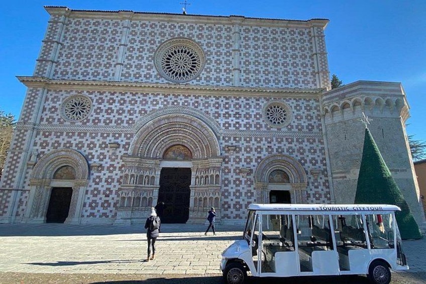 Un bâtiment historique orné de motifs complexes en mosaïque, doté d’une grande entrée en arc de cercle et d’un minaret. 2
