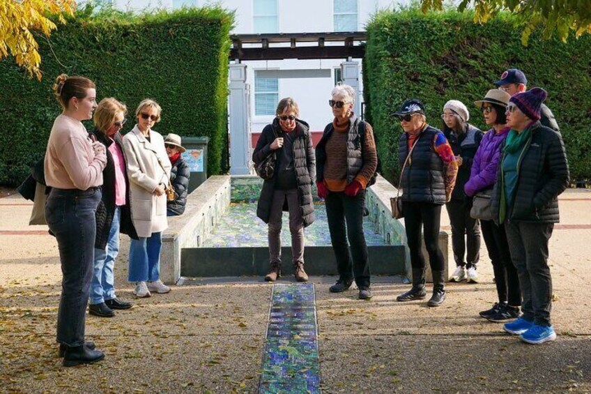 En gruppe mennesker står i en park i nærheden af en springvand. 1