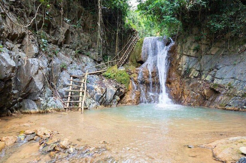 A waterfall, a wooden ladder, and a rocky terrain. 1