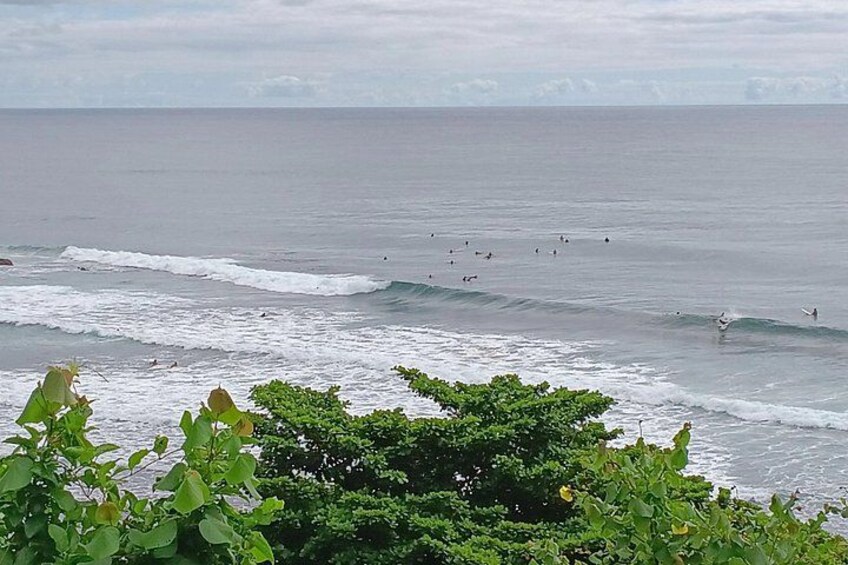 Une plage avec des vagues, des surfeurs et un ciel nuageux. 2