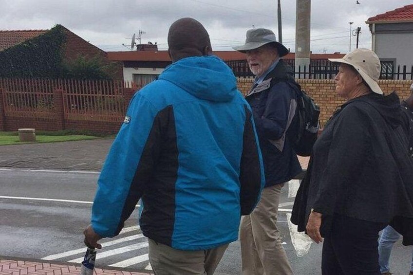 Three people walking on a sidewalk. 5