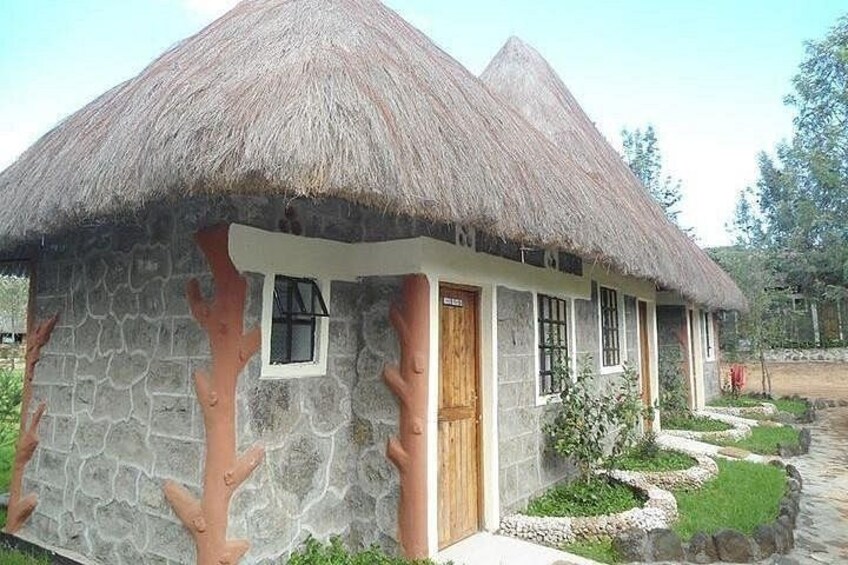 A thatched-roof house with a stone facade, a wooden door, and a window. 2
