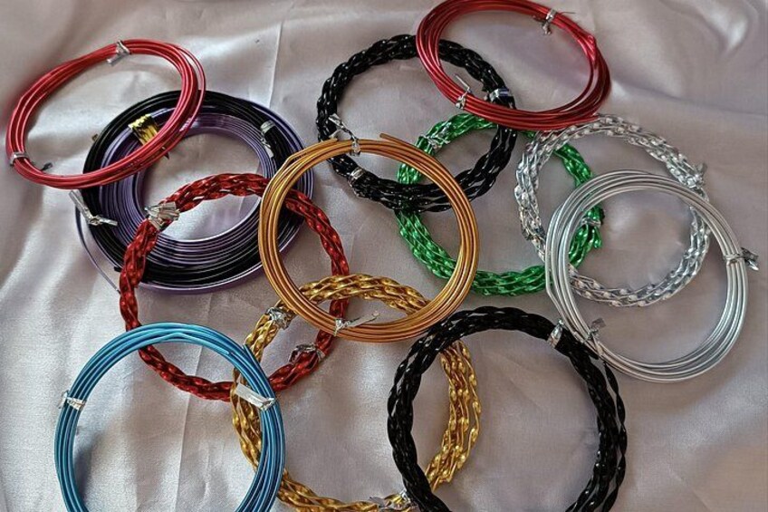 Une collection de bracelets colorés disposés sur une surface en tissu. 1