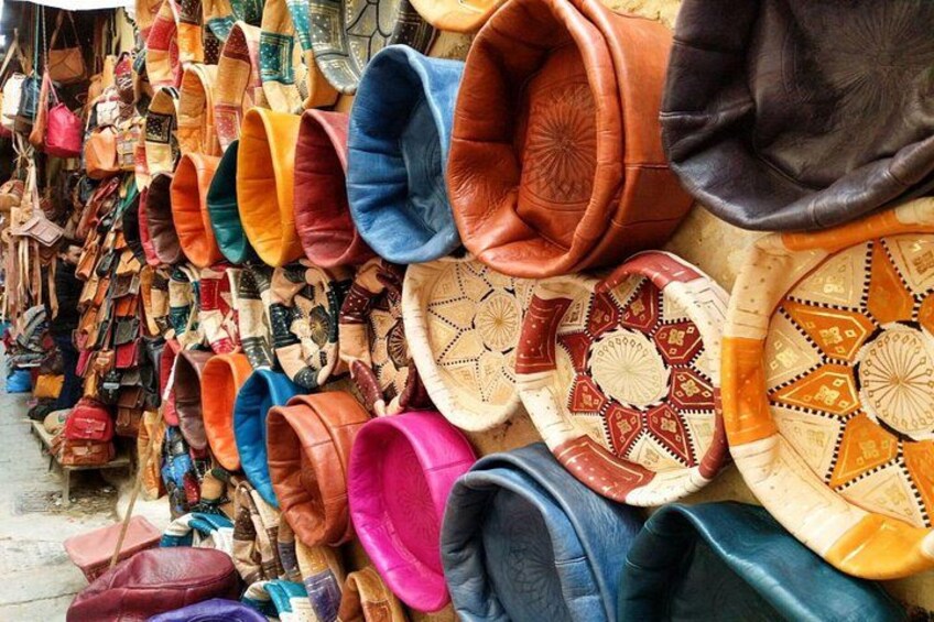 A variety of colorful woven baskets and bags displayed against a wall. 2