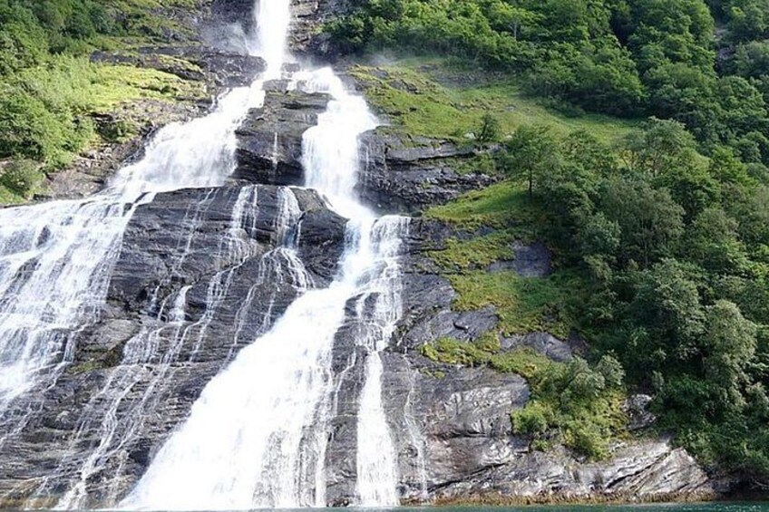 A multi-tiered waterfall surrounded by lush greenery. 4
