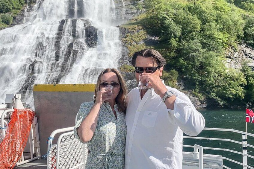 A waterfall, a person in a white shirt, and a person in a patterned shirt. 5