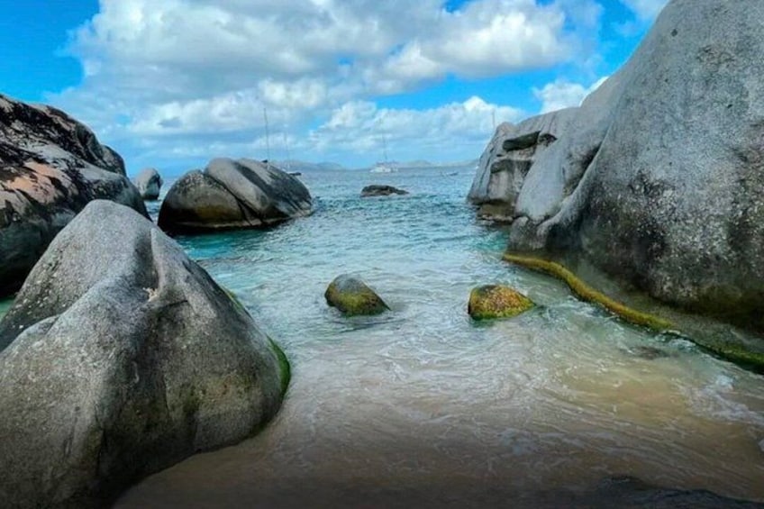 A rocky shoreline with large boulders and calm water. 2