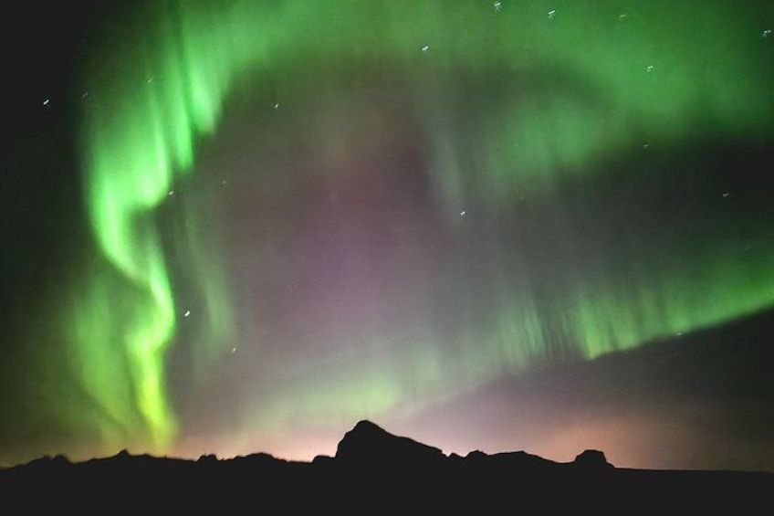 The Northern Lights over a mountainous landscape. 1