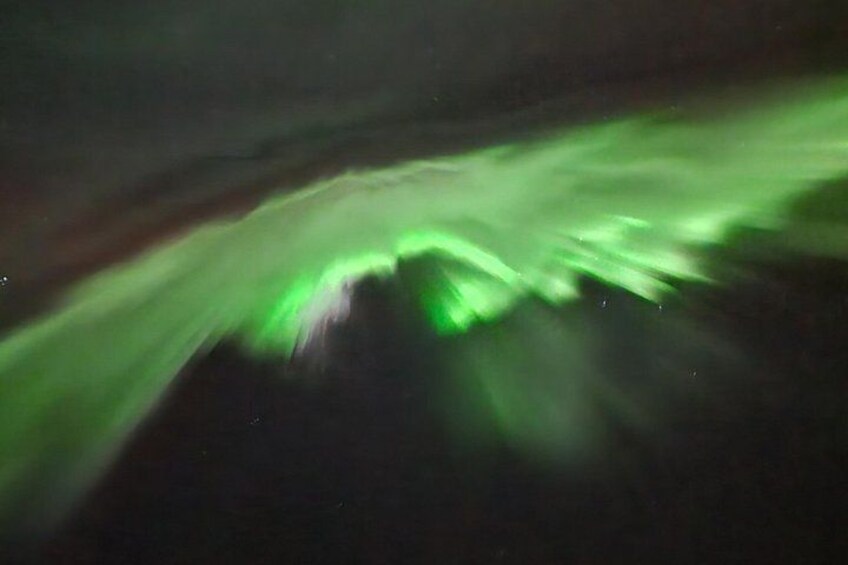 A blurred view of a green light display, likely from an aurora or similar natural phenomenon. 2