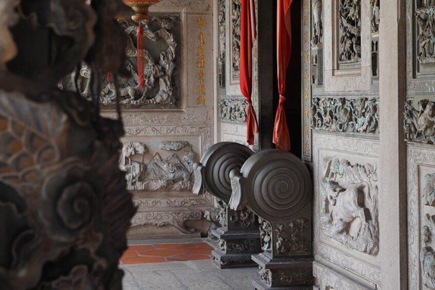 Ornate wall carvings, a red curtain, and a staircase. 2