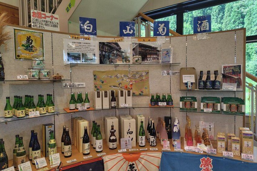 A store with shelves of green bottles, possibly sake, and various Japanese items. 3