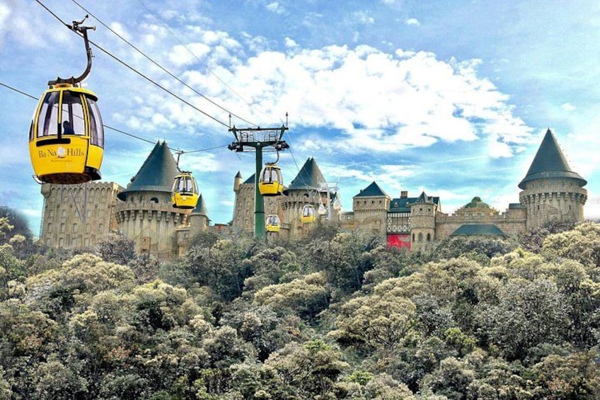 Un castillo con múltiples torres, un sistema de teleférico y abundante vegetación. 5