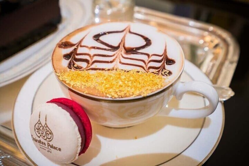 Koffie met chocolade decoratie, een koekje en een beker met een logo. 3