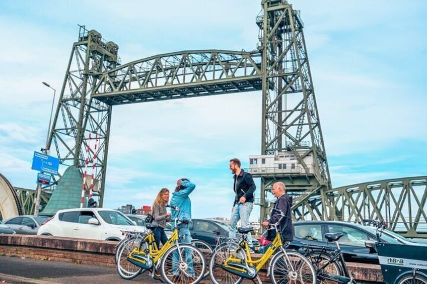 En grupp människor står på en bro, och ovanför dem finns en stor metallkonstruktion. 3