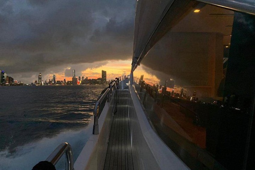 Cubierta de barco con vista a un horizonte urbano al atardecer. 3