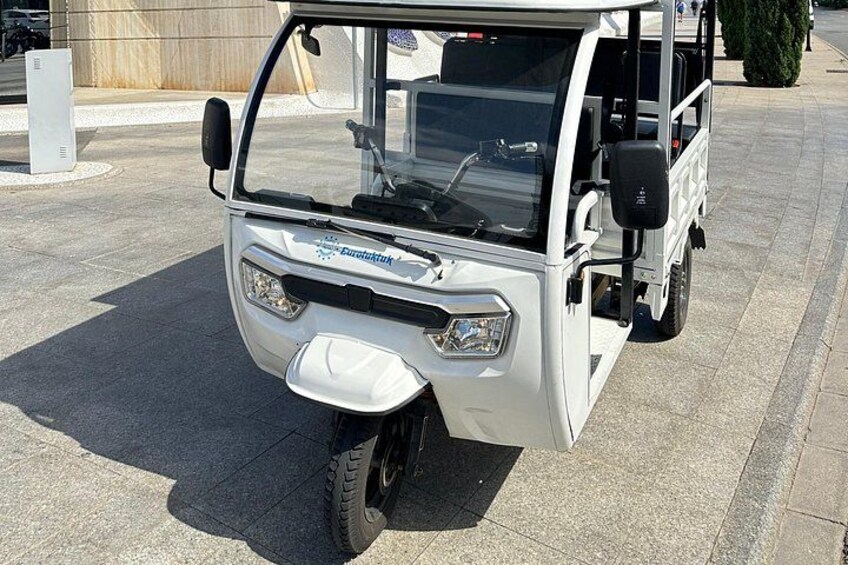 A white golf cart parked on a paved surface. 2