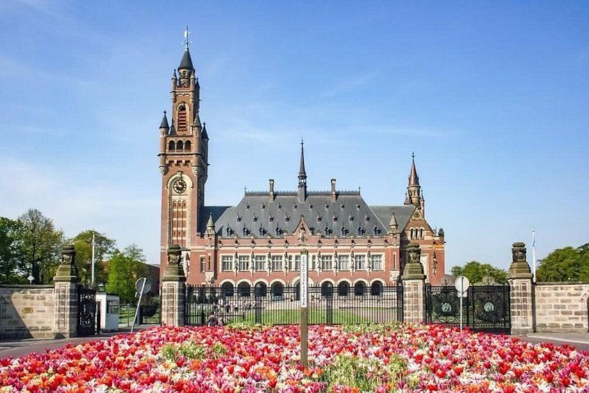 Un bâtiment historique doté d’un clocher, entouré d’un parterre de fleurs. 2