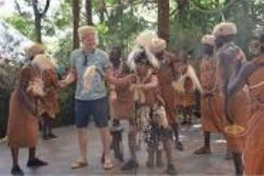 A group of people in traditional attire, possibly a cultural or historical reenactment, in a wooded area. 1