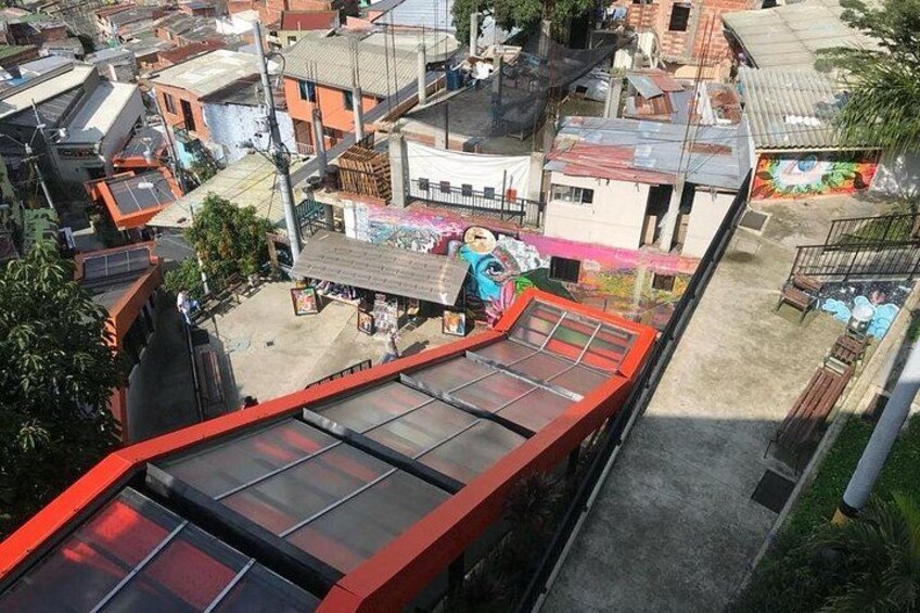 Un edificio de techo rojo con un techo plano, rodeado por otras construcciones de diversos colores de techo. 3