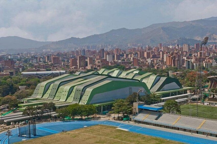 Un estadio con techos verdes, rodeado por un paisaje urbano y montañas. 5