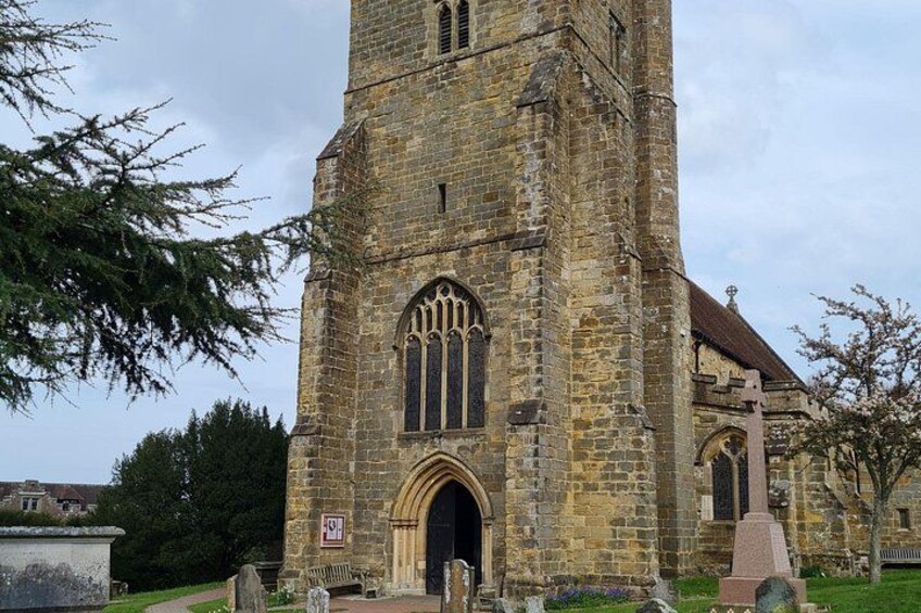 A historic stone church with a tall bell tower, arched windows, and a large entrance door. 4