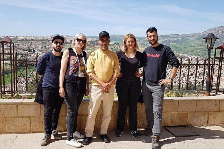 Un grupo de personas en un balcón con un paisaje urbano de fondo. 2
