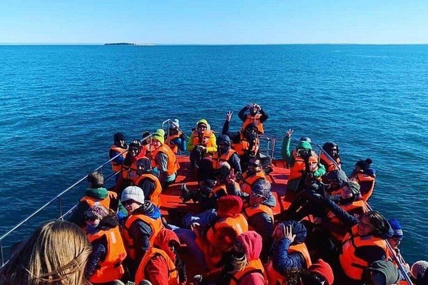 A boat with people wearing orange life jackets. 2