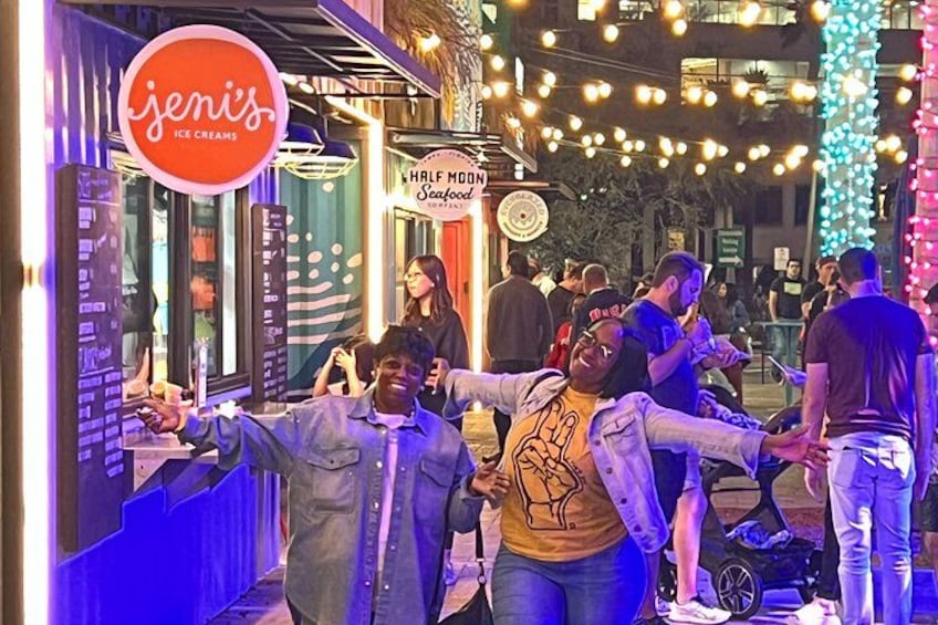 An ice cream shop named 'jenis' with a signboard, a 'Half Moon Seafood' restaurant, and people standing outside. 2